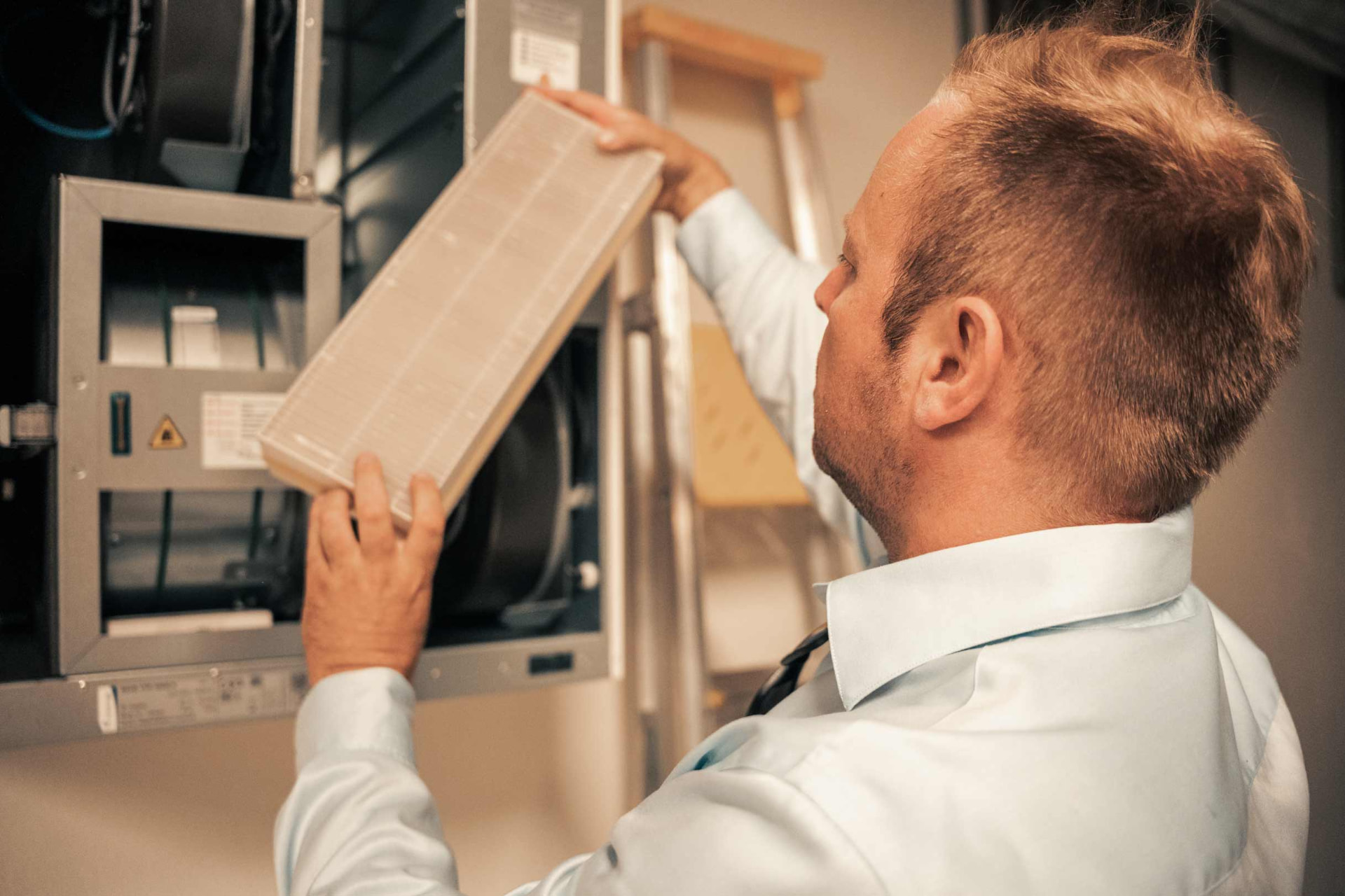 Takstmann kontrollerer filter i et ventilasjonsanlegg under befaring av bolig