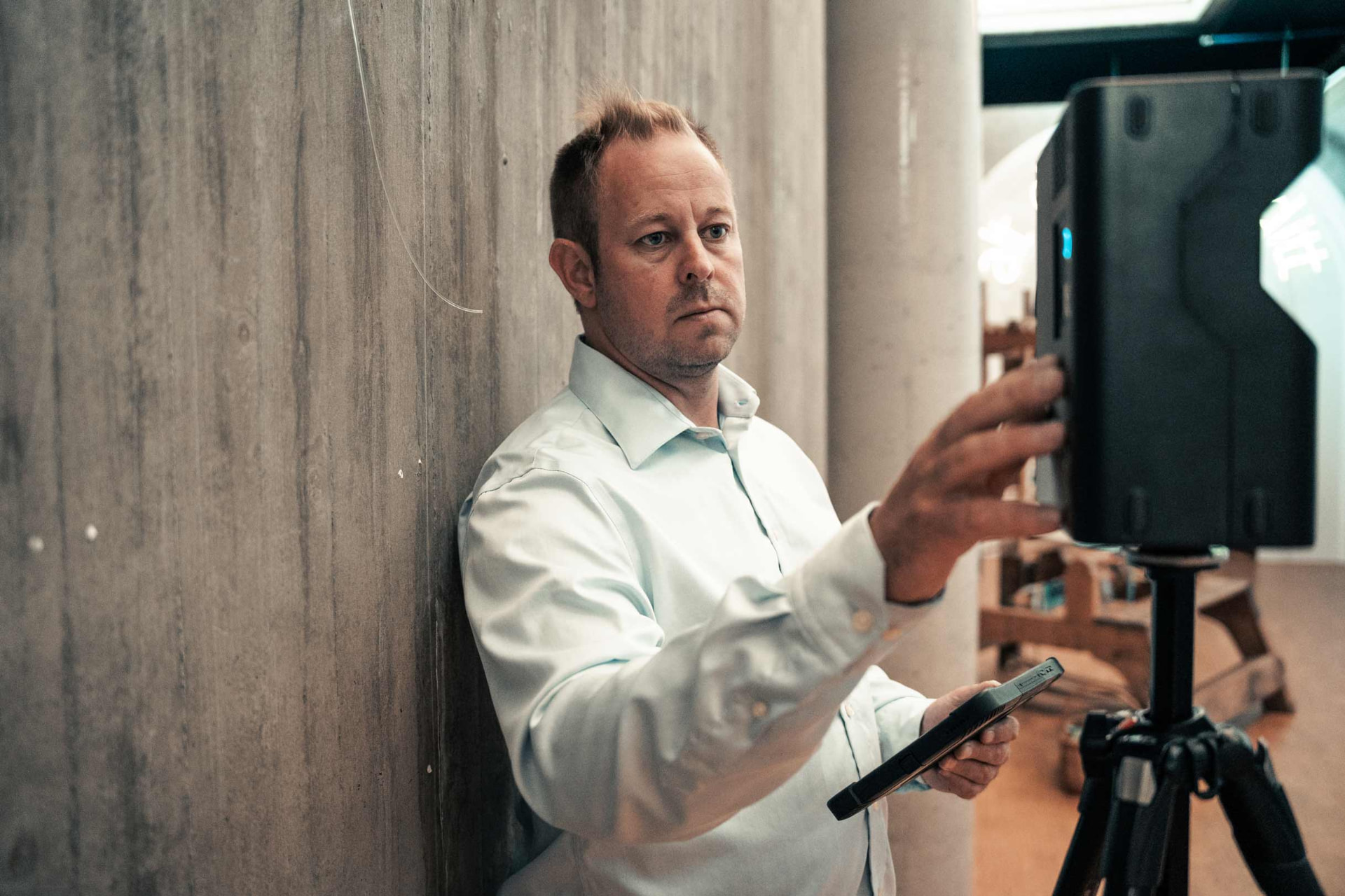 Takstmann stiller inn 3D-skanner på stativ under befaring av bolig